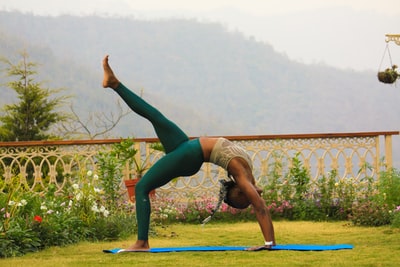 穿着青绿色紧身裤的女人摆出瑜伽姿势